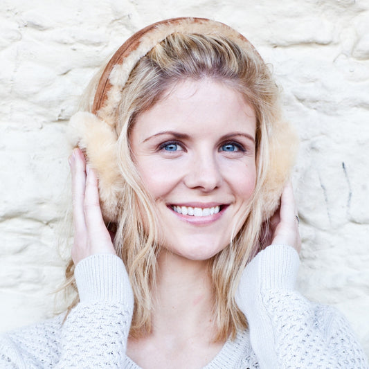 Natural Sheepskin Earmuffs, worn by a Blonde Female Model smiling.
