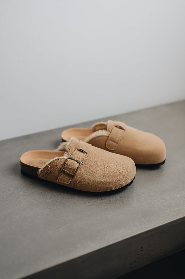 High angle of baba tabac showing of its adjustable strap and metal buckle as well as its fluffy inside 