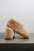 Side view of a camel coloured curly merino sheepskin boot slipper.