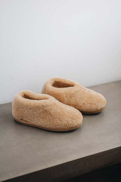 Top and side view of a camel coloured curly merino sheepskin boot slipper.