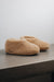 Side view of a camel coloured curly merino sheepskin boot slipper.