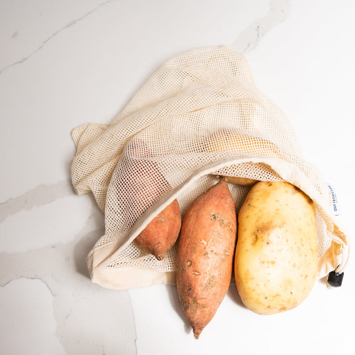 Cotton reusable mesh produce bag, holds potatoes inside.