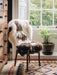 British Jacob rug in Natural white and brown spots draped over a wooden chair