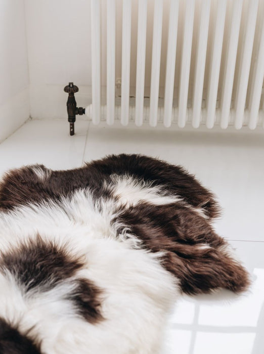 Close up of a British Jacob rug in Natural white and brown spots on a bathroom floor