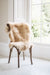 Natural melange  coloured Swedish Sheepskin Rug draped over a wooden chair sitting in a window