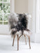 Natural grey undyed Icelandic Sheepskin Rug draped over a wooden chair settled in a window