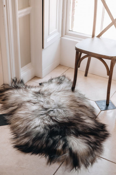 Natural grey undyed Icelandic Sheepskin Rug laid  on a tiled floor in a window nook.