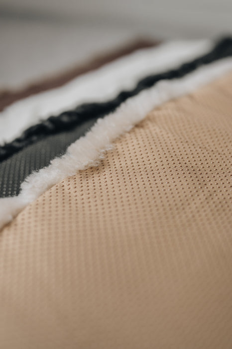 Close-up of a the rubber non
-slip underside of an oatmeal coloured sheepskin pet bed