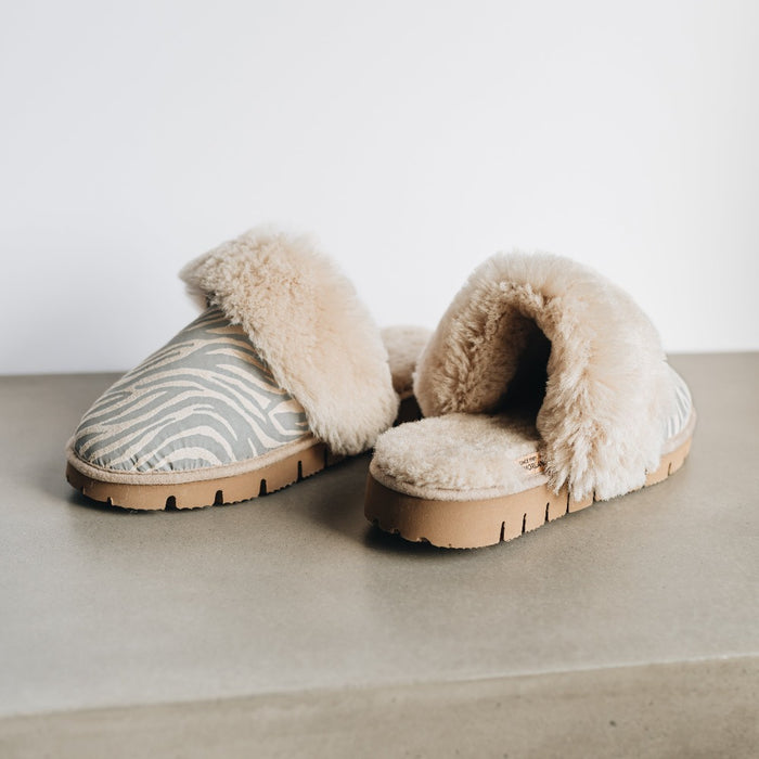 AW22 Veroncia Sheepskin Animal Print Slippers from Westmorland Sheepskin. Grey Zebra Print Slippers, with Sheepskin cuff and hard wearing brown sole.