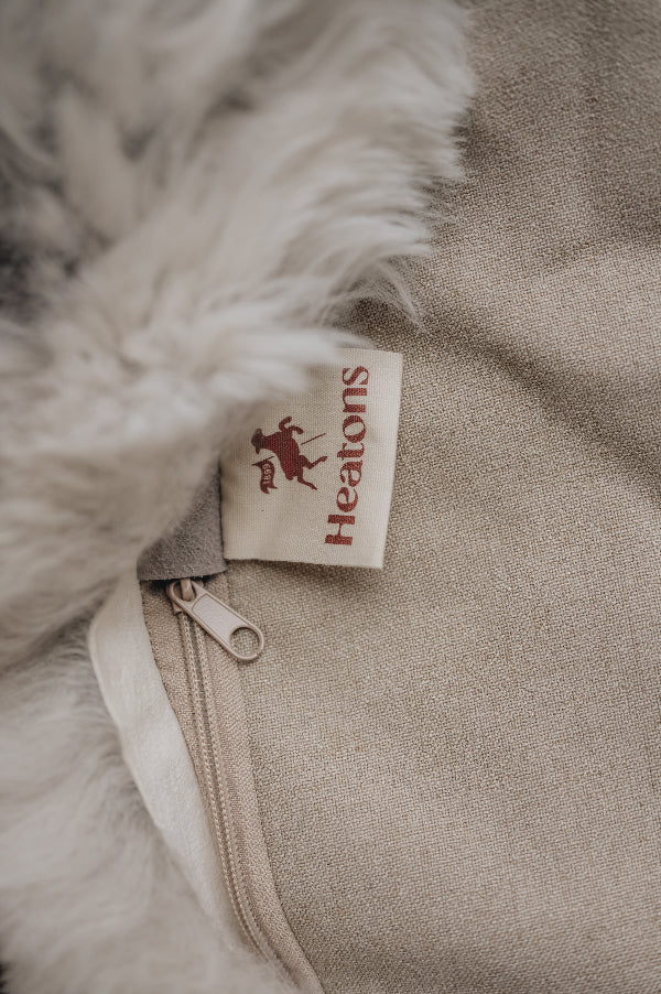 Close-up of a natural cotton Heaton's label on the bottom of a natural melange sheepskin bean bag.
