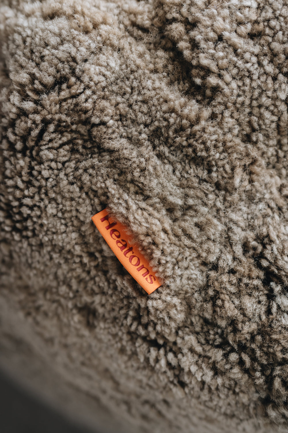 Orange cotton label with 'Heatons' branding on a wheat sheepskin beanbag.