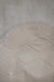 Close-up of a textured light fabric with a honeycomb pattern on the back / underside of a white sheepskin rug