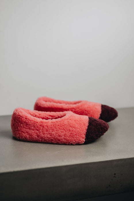 Side view of soft-soled ballerina style curly pink sheepskin slipper with burgundy toe point