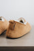Rear view of Grace, a light soft-soled sheepskin slipper showing the detail of the suede tag and label.