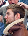 Man sat in barbers chair having his hair done, wearing a Men's Brown Sheepskin Aviator Jacket with a turned up Sheepskin collar.