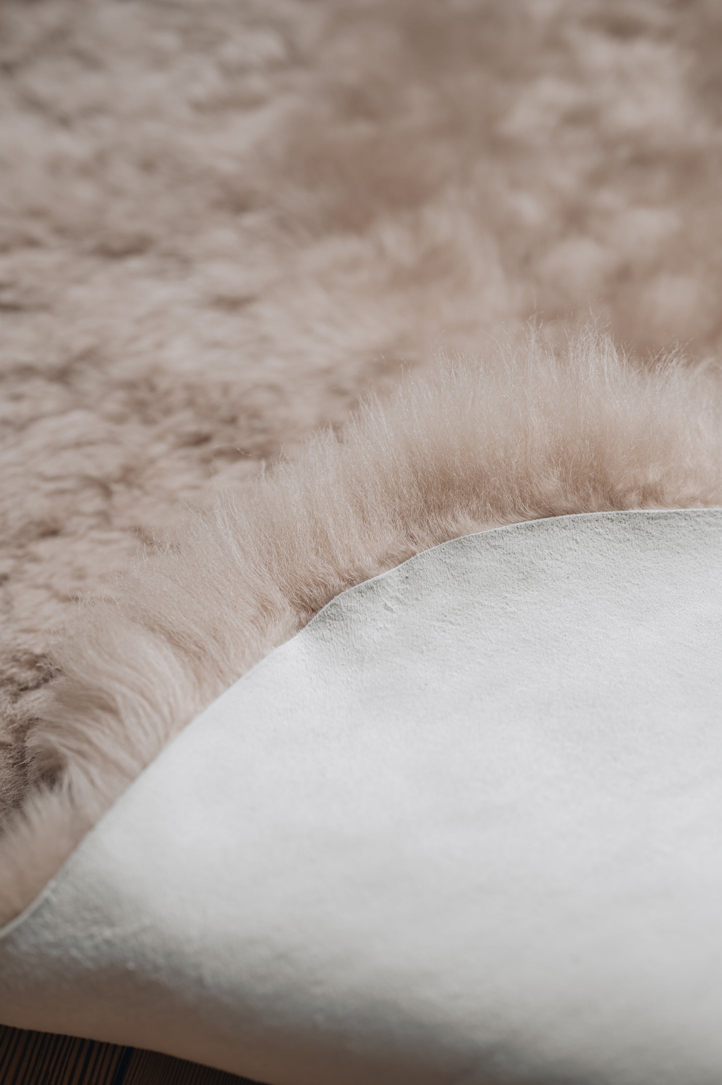 Close up of a dyed sheepskin in  the colour nude, sheepskin is folded back on itself to show off both sides of the sheepskin