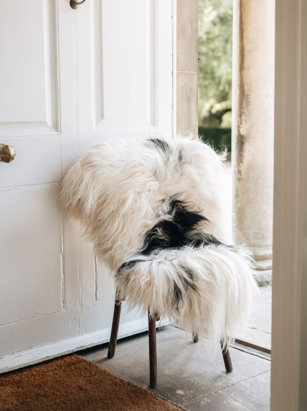 Icelandic natural spotted sheepskin white and black draped over a chair