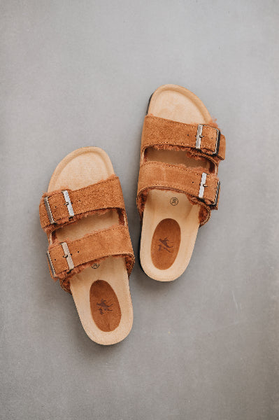Birds eye view of the sandals and their metal buckles and sheepskin straps