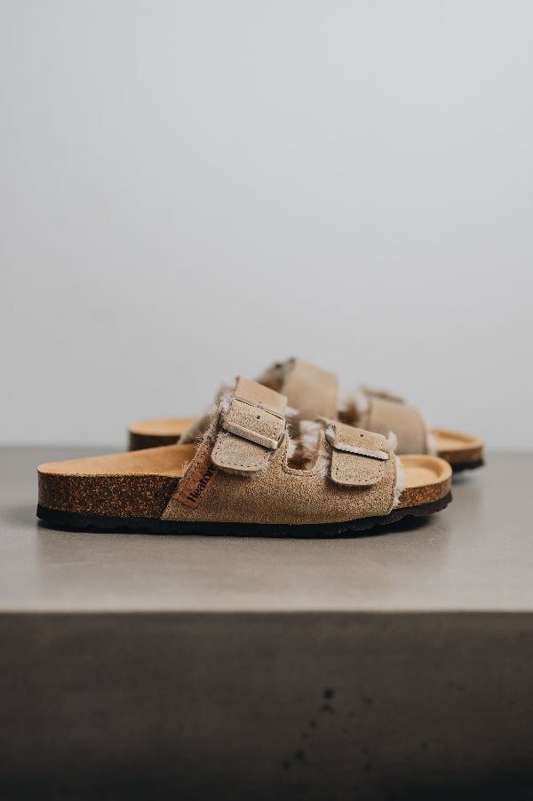 Side angle of the mead vanilla sandals showing of the side profile and natural biodegradable cork souls
