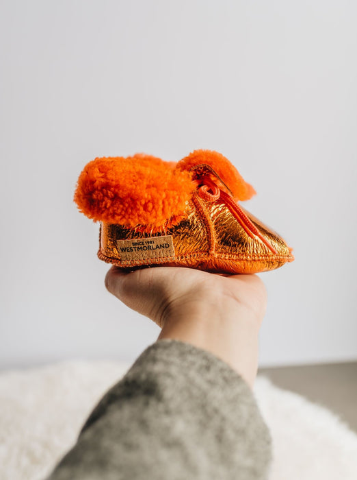 Westmorland Sheepskins Soft Soled Orange foil Baby Sheepskin Boots with a dyed Orange Sheepskin Cuff and laces.