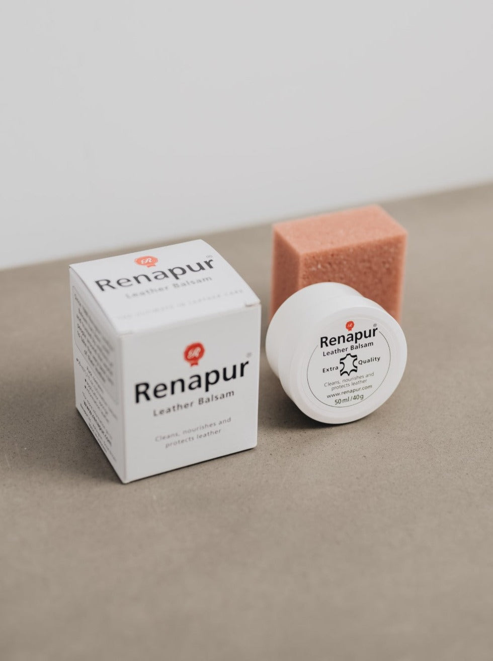 Small white box with Renapur branding, small white pot of leather balm and orange/brown applicator sponge