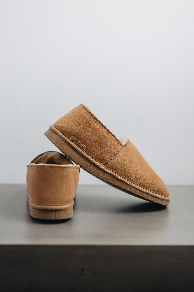 Side and rear view of clean loafer style sheepskin slipper, hand crafted from Spanish merino sheepskin.