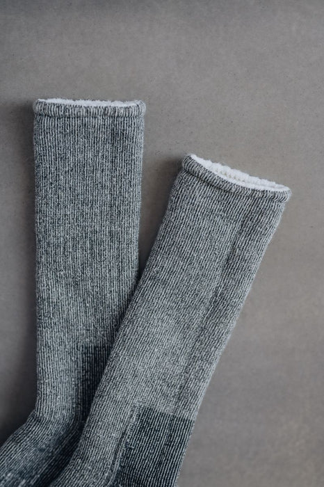 Pair of grey and black merino wool walking socks on a grey background