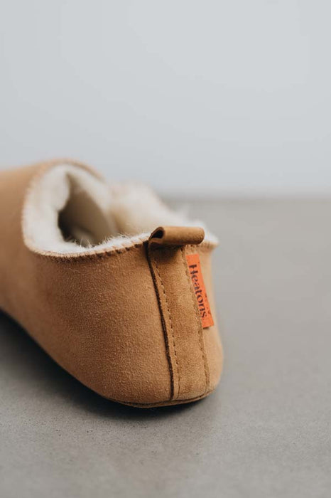 Rear view of Grace, a light soft-soled sheepskin slipper showing the detail of the suede tag and label.
