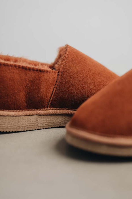 Close up of rust coloured loafer style sheepskin slipper