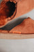 Close up of rust coloured slip on style sheepskin slipper 