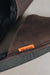 Close up of brown coloured slip on style sheepskin slipper with orange cork label showing the Heatons brand