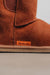 Close-up of a rust sheepskin slipper boot with 'Heaton's' logo on a light grey background