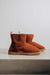 Profile view of rust coloured sheepskin boots with 8mm rubber sole on a light concrete background.