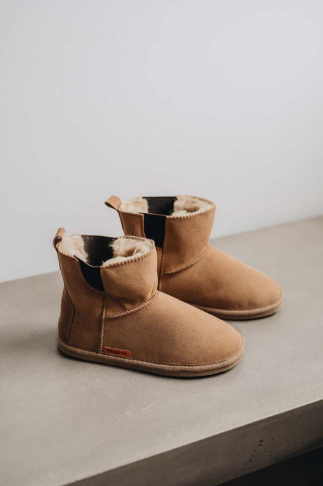 Pair of tan sheepskin boots with dark brown elasticated panels on the sides.