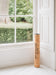 A Yoga mat of natural latex rubber, topped with soft and sustainable Portuguese cork standing next to window - space saving