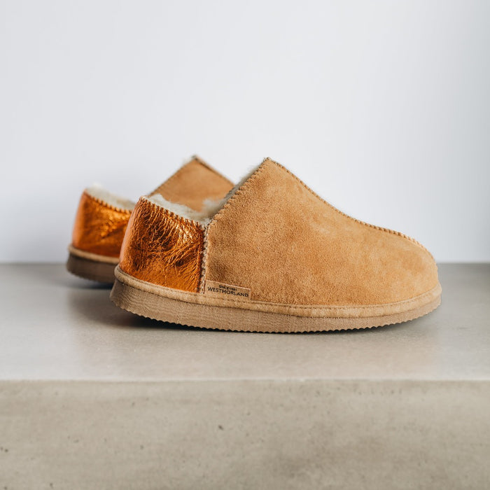 Side view of CADI Tan Sheepskin Women's Slipper, designed by Westmorland Sheepskins. The ankle has a contemporary Orange Foil look. Features a small branded cork tag sewn into outer trim.