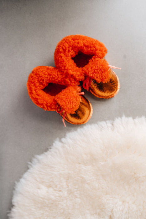 Top down view of Westmorland Sheepskins Soft Soled Orange foil Baby Sheepskin Boots with a dyed Orange Sheepskin Cuff and laces.