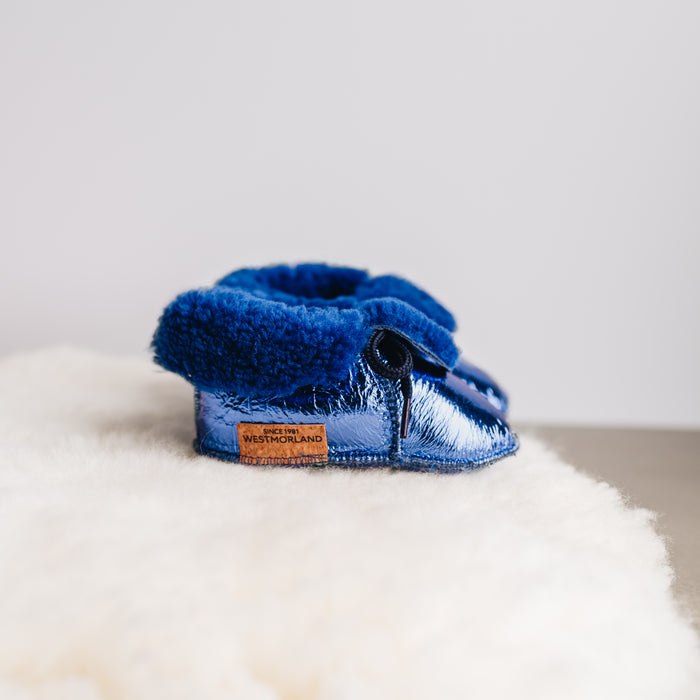 Side view of Westmorland Sheepskins Soft Soled Metallic Blue foil Baby Sheepskin Boots with a blue Sheepskin Cuff and laces.