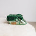 Side view of Westmorland Sheepskins Soft Soled Metallic Mint (green) foil Baby Sheepskin Boots with a green Sheepskin Cuff and laces.