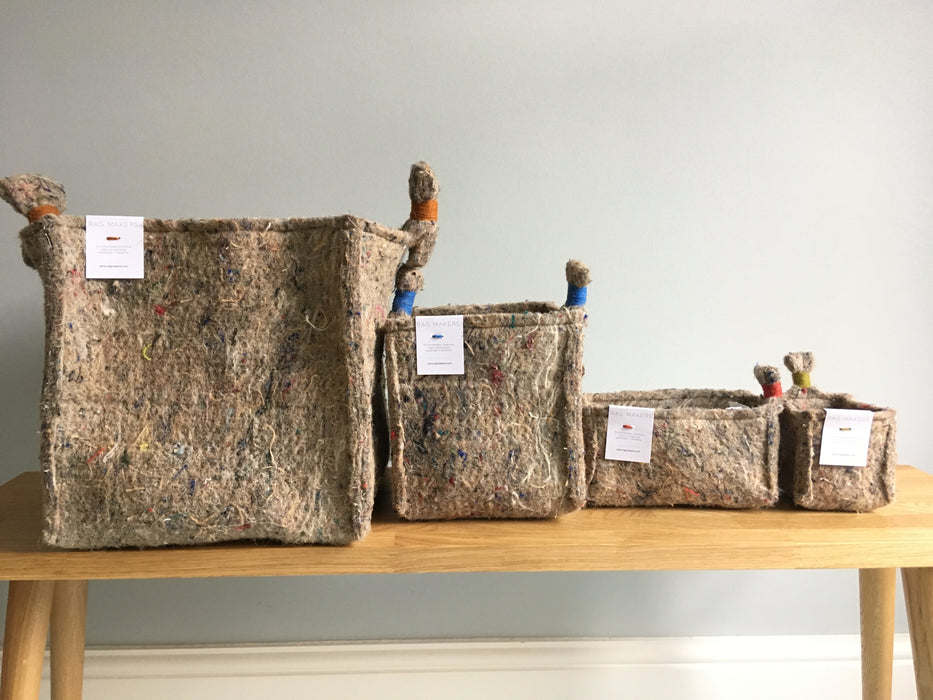 Various sizes of Elland Storage wool felt cubes from Ragmakers. To the left is the largest cube, to the right is the smallest cube. Each cube has colourful string handles, including orange, blue, red and yellow.