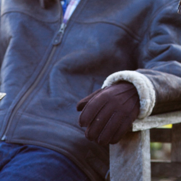 Men's Handsewn Sheepskin Gloves in Brown. Worn by a male model in a Leather Aviator jacket.