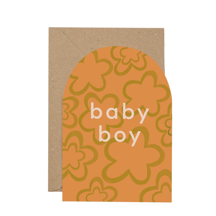 'baby boy' Curved Greetings Card. A soft peach/orange background with olive green flower shapes, features white writing in the centre reading 'baby boy'. Comes with an envelope.