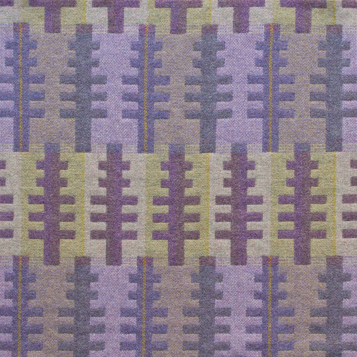 Close up of reverse of Forest woven wool textiles by Melin Tregwynt. Features tree like shapes in purples set against a green and purple striped background.