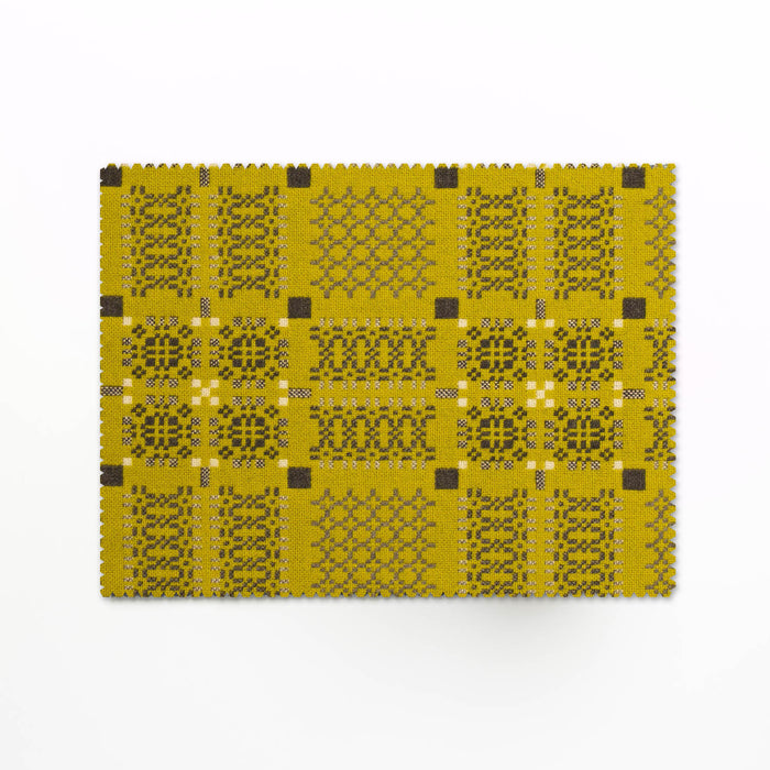Melin Tregwynt Knot Garden Tablemats in Gorse Yellow. Gorse woven wool tablemats, features a repeating pattern in grey, whte and daffodil yellow.