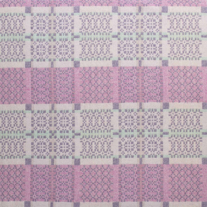 Lilac reverse fabric for Purple Melin Tregwynt Knot Garden Woven Wool Throw. A light Lilac colour, with detail pattern in white, pale blue and purple.