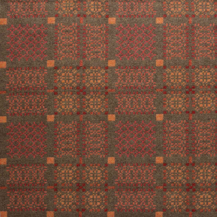 Copper fabric for Orange Melin Tregwynt Knot Garden Woven Wool Throw. A rusty copper colour, with detail pattern in rust red, pale orange and grey.