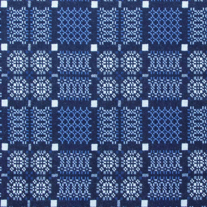 Indigo Fabric for Blue Melin Tregwynt Knot Garden Woven Wool Throw. A deep Indigo blue colour, with detail pattern in white, grey and light blue.