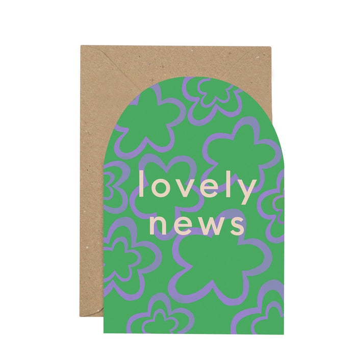 Lovely News Curved Card. A rounded top verticle card, features a green and purple floral background. In the centre of the card reads 'lovely news'. Comes with an envelope.