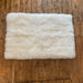 Icelandic Designer Sheepskin Rug in White, photographed on wooden floor.